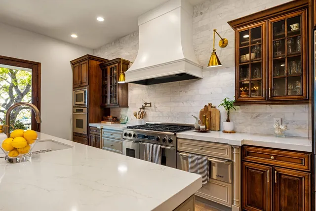 a kitchen with stainless steel appliances a stove a sink and a refrigerator
