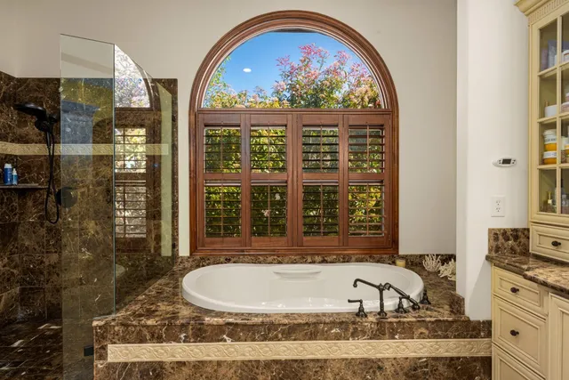 a bathroom with a granite countertop sink vanity mirror and toilet
