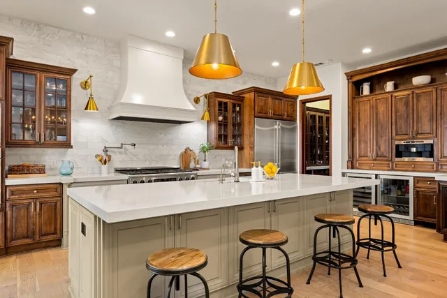 a kitchen with stainless steel appliances granite countertop a stove a sink and a refrigerator
