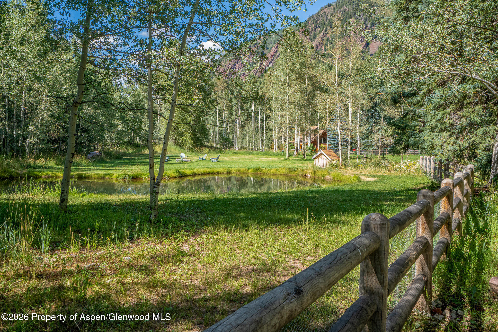 285 Conundrum Creek Road Aspen, CO 81611 - Photo 11 of 35 a view of a lake with a yard and large trees