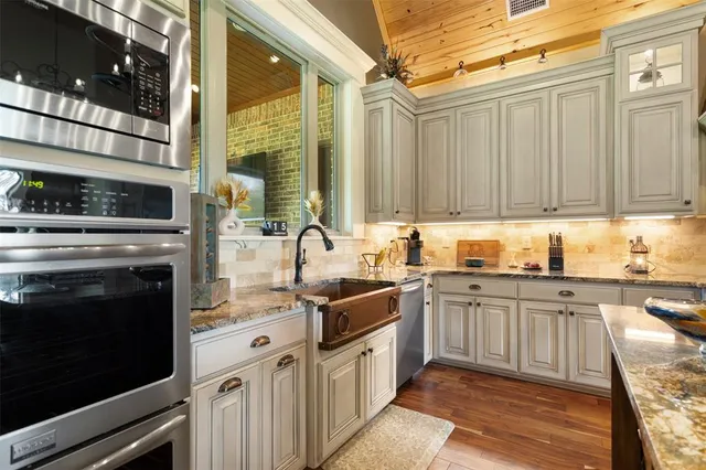 a kitchen with stainless steel appliances granite countertop a sink stove and cabinets