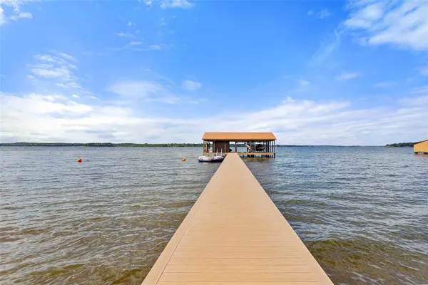 an aerial view of a house with a yard basket ball court and trees in the background