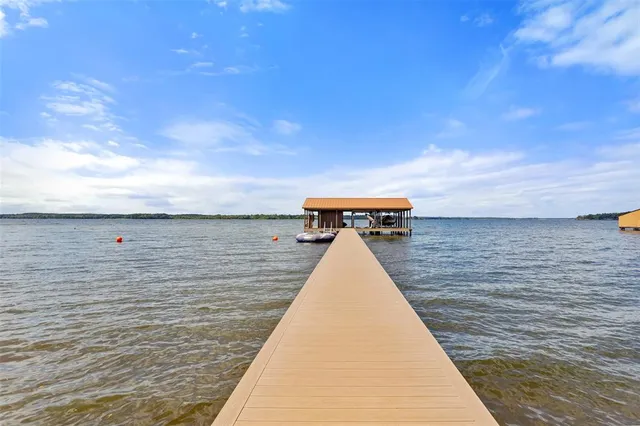 an aerial view of a house with a yard basket ball court and trees in the background