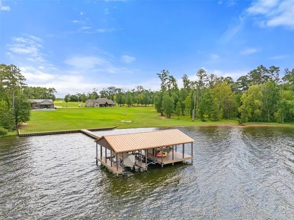 a view of a house with a yard from a lake view