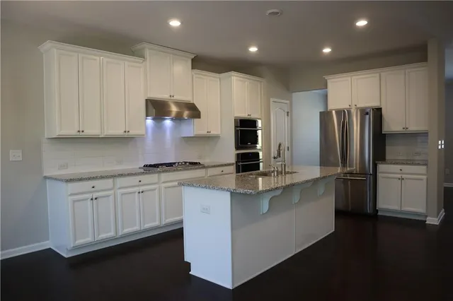 a kitchen with stainless steel appliances granite countertop a refrigerator sink and cabinets