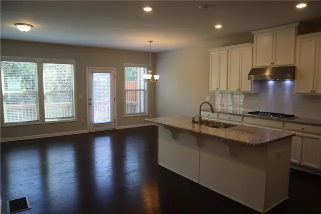 a kitchen with sink cabinets and wooden floor