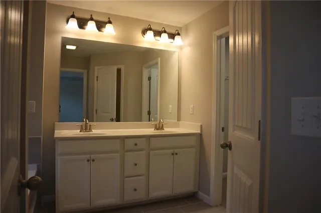 a bathroom with a double vanity sink and a mirror