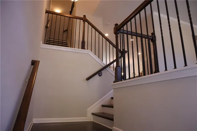 a view of staircase with wooden floor and white walls