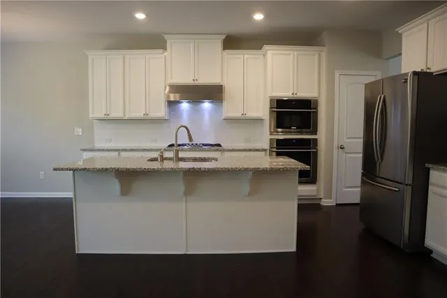 a kitchen with kitchen island stainless steel appliances a refrigerator a stove a microwave and cabinets