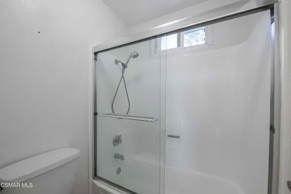 a bathroom with a shower a toilet and a window