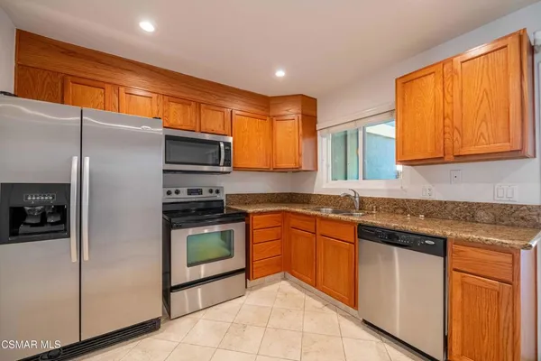 a kitchen with stainless steel appliances granite countertop a refrigerator and a sink