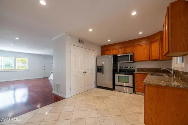 a kitchen with stainless steel appliances granite countertop a refrigerator and a sink