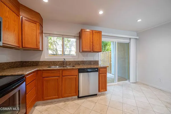 a kitchen with stainless steel appliances granite countertop a sink and a stove