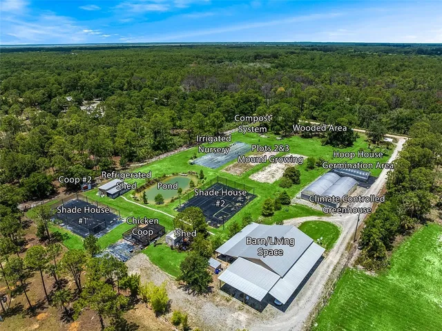an aerial view of residential houses with outdoor space and trees