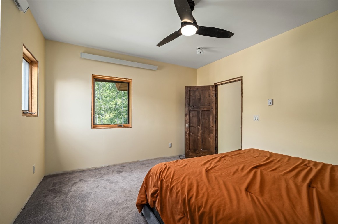 29195 River Drive Clark, CO 80428 - Photo 15 of 36 a bed sitting in a bedroom next to a window and a chandelier