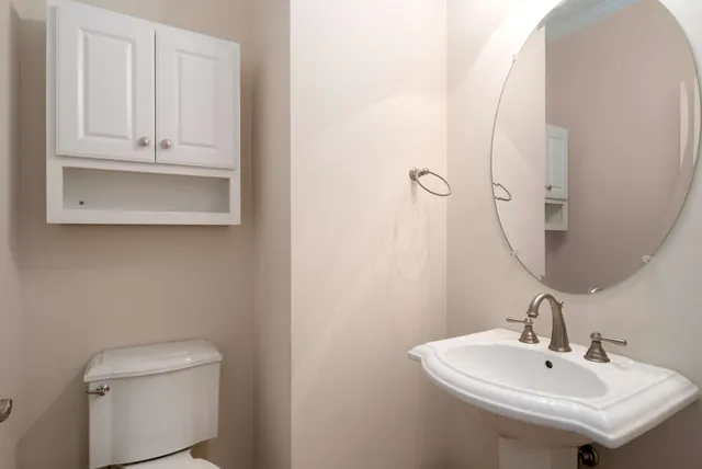 a bathroom with a sink a toilet and mirror