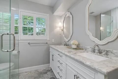 a bathroom with a granite countertop sink a mirror and a shower