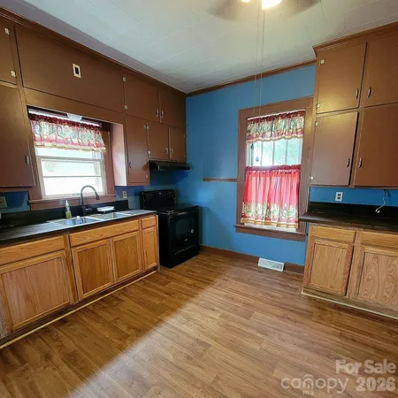 a kitchen with stainless steel appliances granite countertop a sink window and cabinets