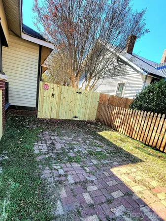 a view of a house with backyard and wooden fence