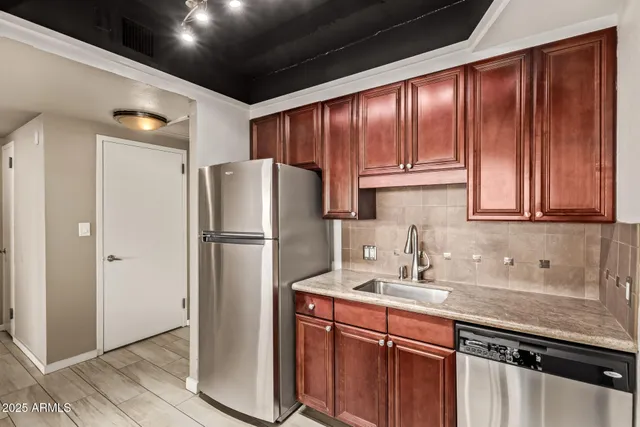 a kitchen with stainless steel appliances granite countertop a refrigerator and a sink