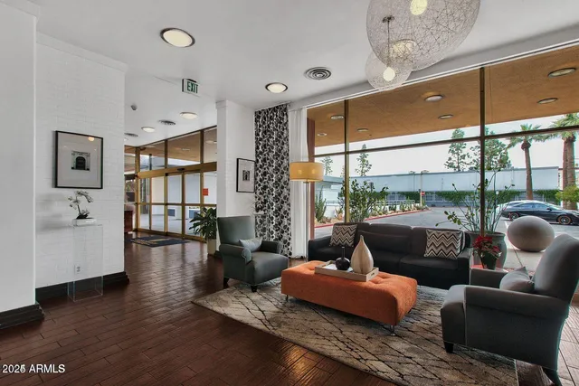 a living room with furniture large window and wooden floor