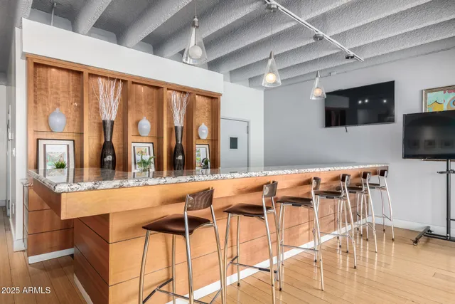 a kitchen with stainless steel appliances kitchen island granite countertop a table chairs and a large window