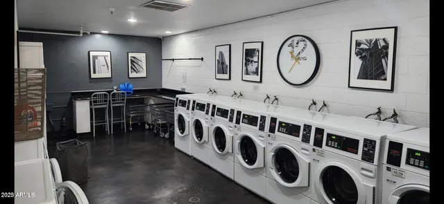 a utility room with stainless steel appliances wooden floor and window