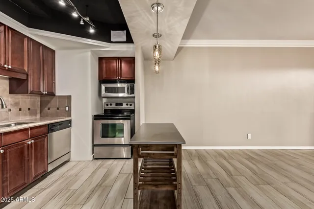 a kitchen with wooden floor electronic appliances and cabinets
