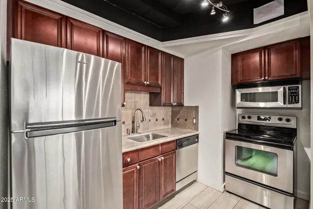 a kitchen with stainless steel appliances granite countertop a refrigerator sink and stove