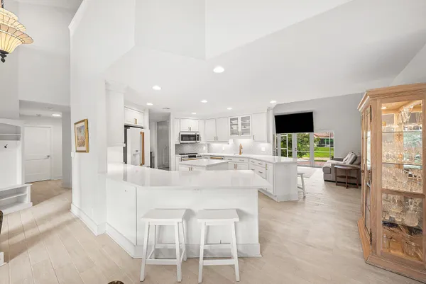 a large white kitchen with white cabinets and couches