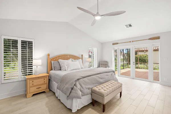 a spacious bedroom with a bed and a flat screen tv