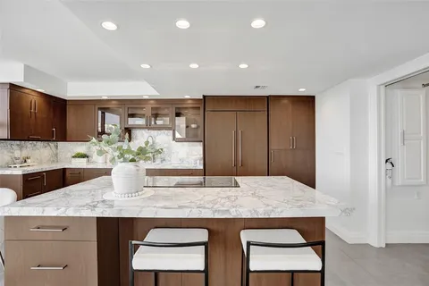 a kitchen with granite countertop kitchen island stainless steel appliances a sink and cabinets