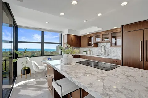a kitchen with stainless steel appliances granite countertop a sink and a refrigerator