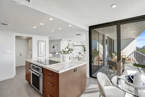 a kitchen with a sink stove and chairs
