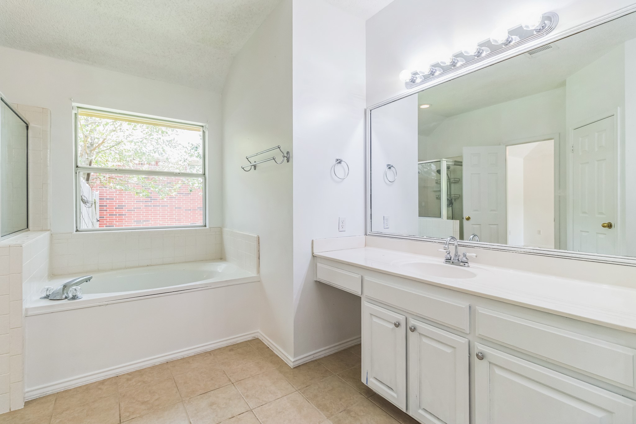 800 Mountain Ridge Drive Leander, TX 78641 - Photo 17 of 31 An alcove bathtub rests beneath a large window, complementing the spacious vanity station.