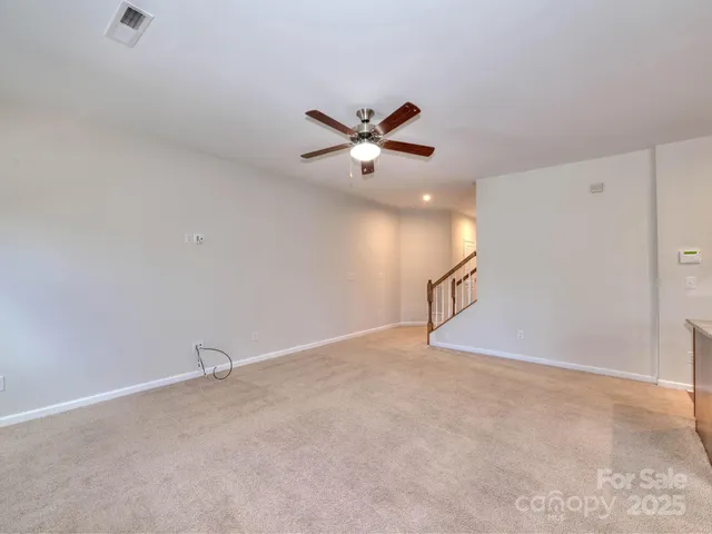 an empty room with closet and a ceiling fan