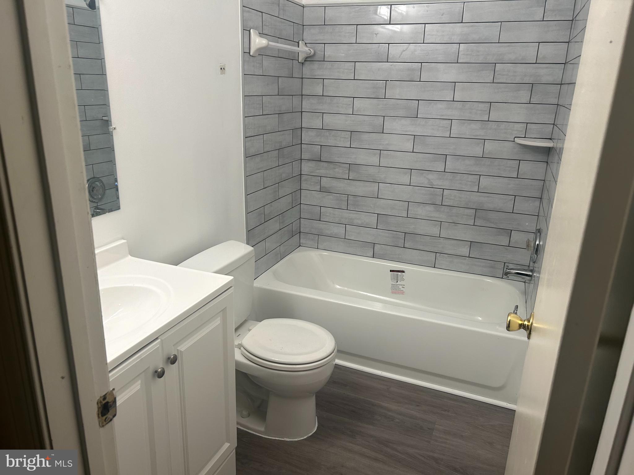 8573 Ritchboro Road District Heights, MD 20747 - Photo 6 of 19 a bathroom with a granite countertop bathtub and toilet