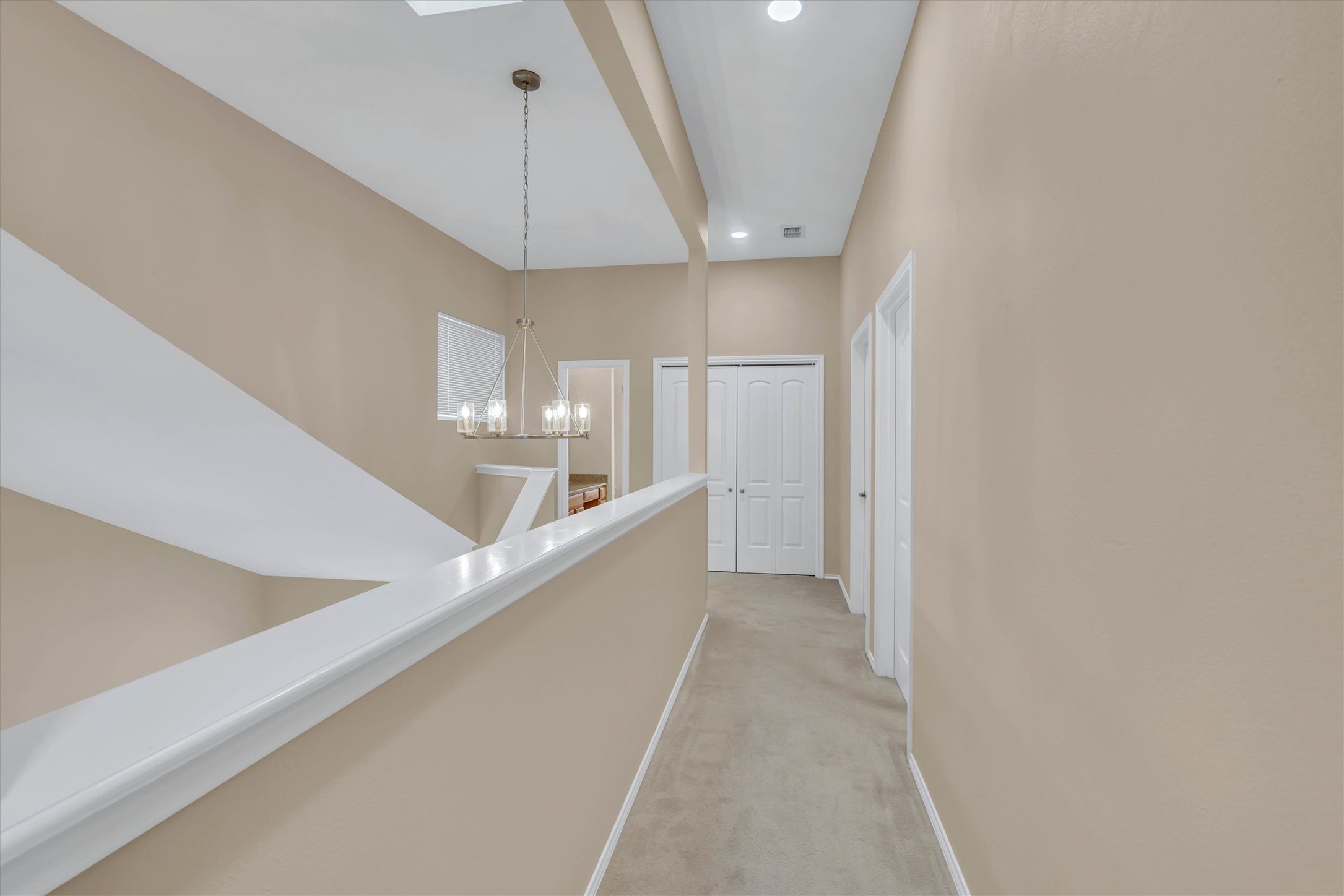 8108 Matchlock Cove Austin, TX 78729 - Photo 20 of 40 Hallway featuring light carpet and hanging lights