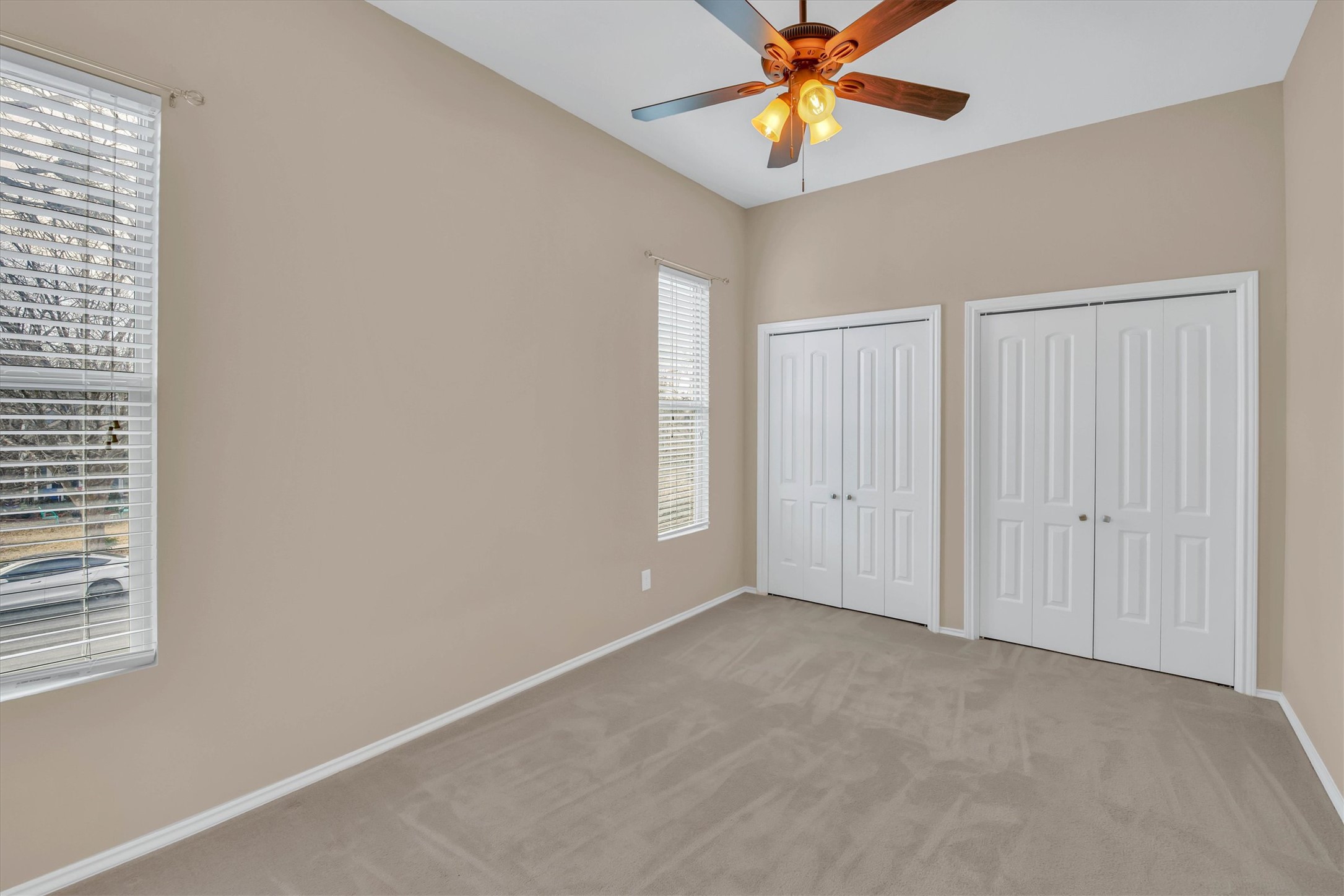 8108 Matchlock Cove Austin, TX 78729 - Photo 23 of 40 Unfurnished bedroom with multiple closets, carpet, and ceiling fan