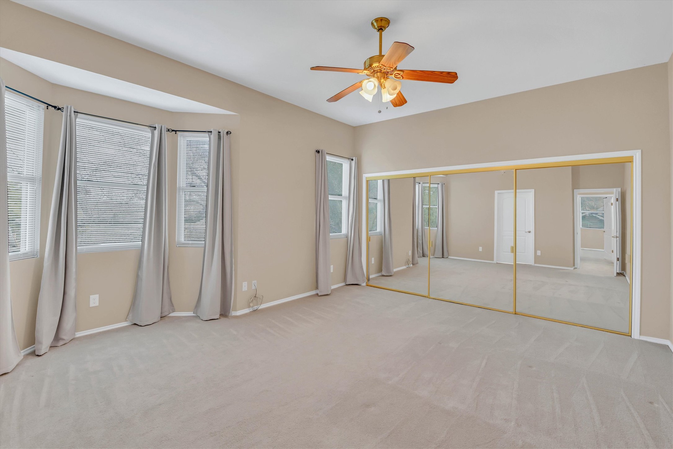 8108 Matchlock Cove Austin, TX 78729 - Photo 24 of 40 Unfurnished bedroom featuring light carpet, a closet, a ceiling fan, and multiple windows