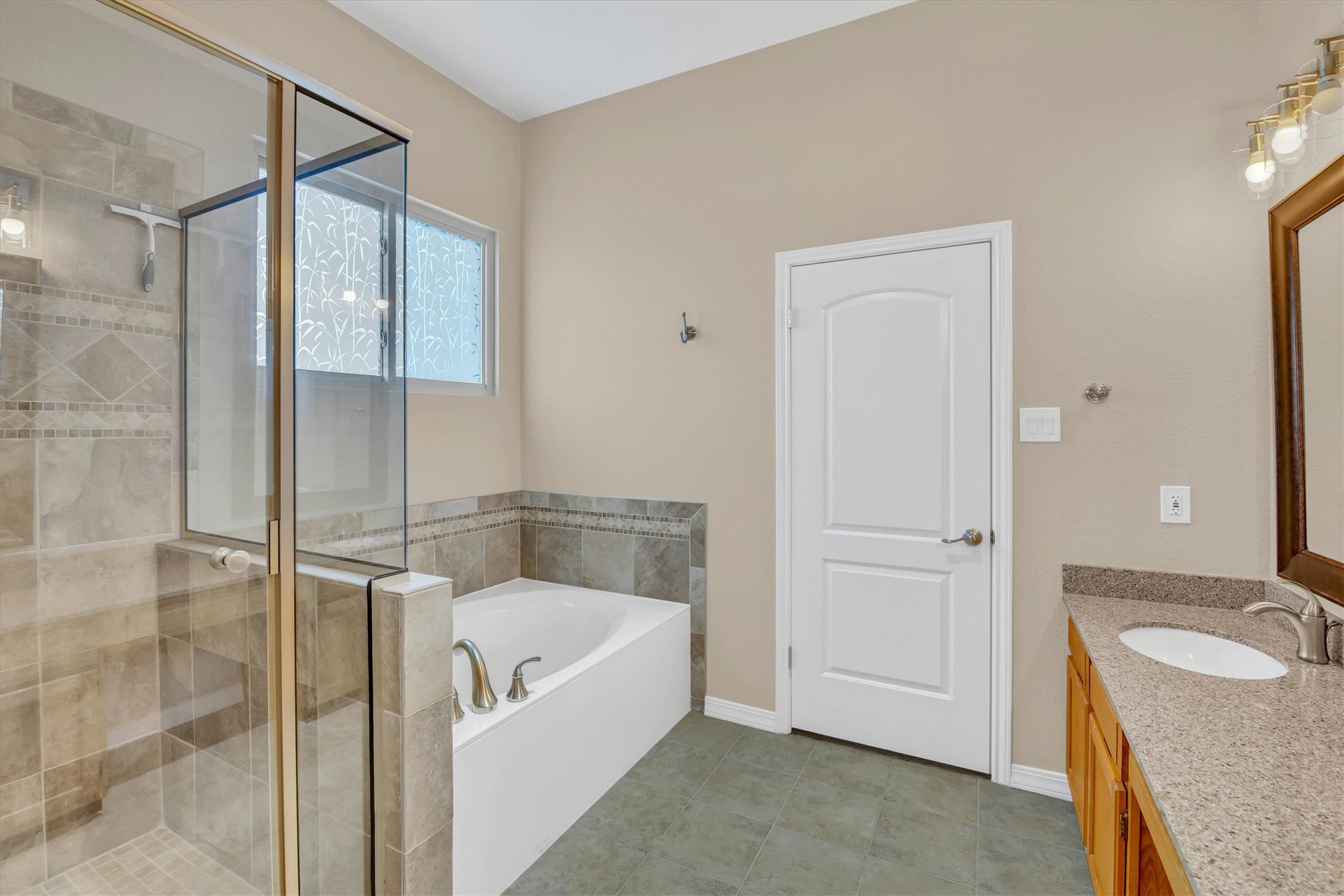 8108 Matchlock Cove Austin, TX 78729 - Photo 27 of 40 Full bath with a garden tub, a stall shower, vanity, and light tile patterned floors