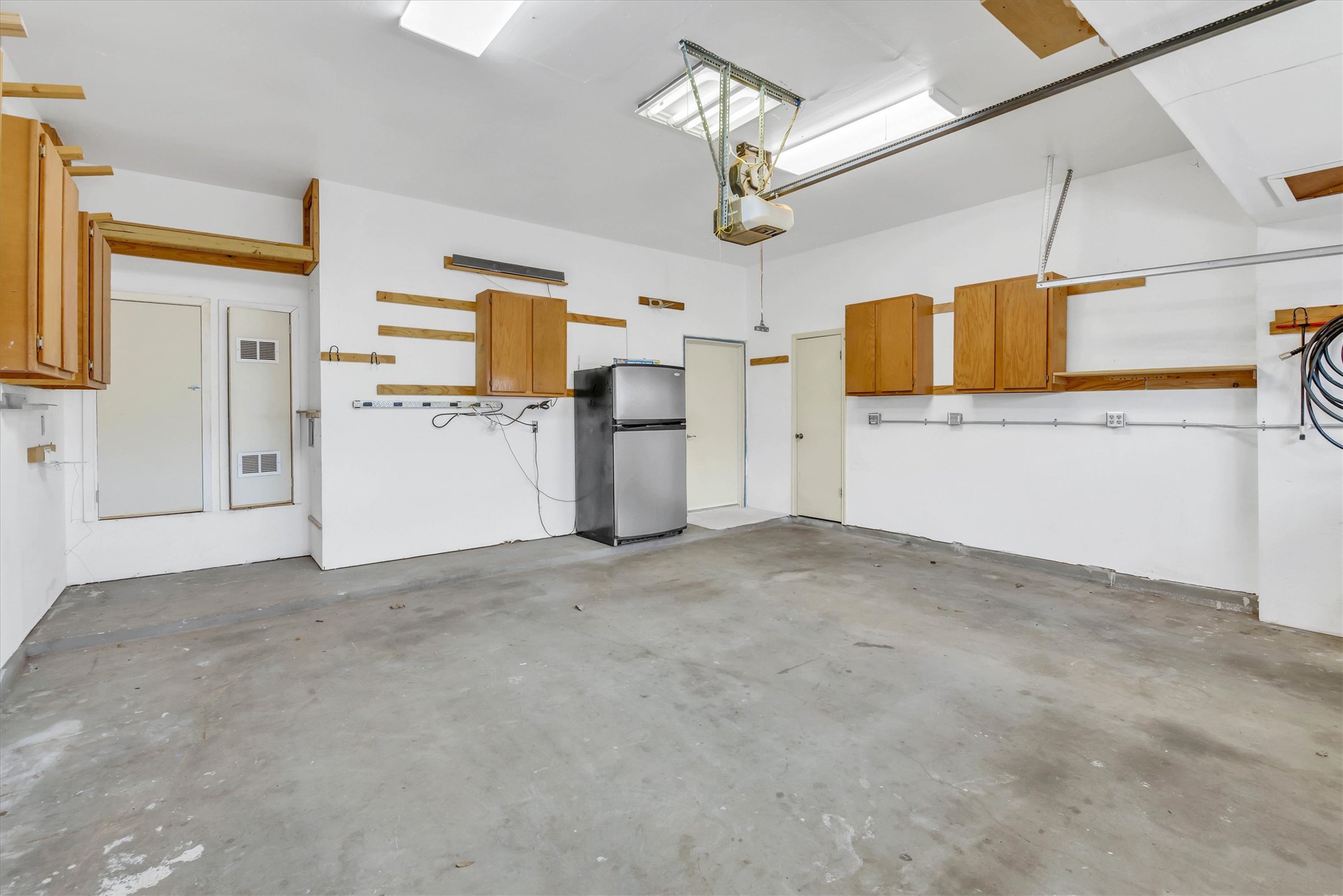 8108 Matchlock Cove Austin, TX 78729 - Photo 37 of 40 Garage with freestanding refrigerator and a garage door opener