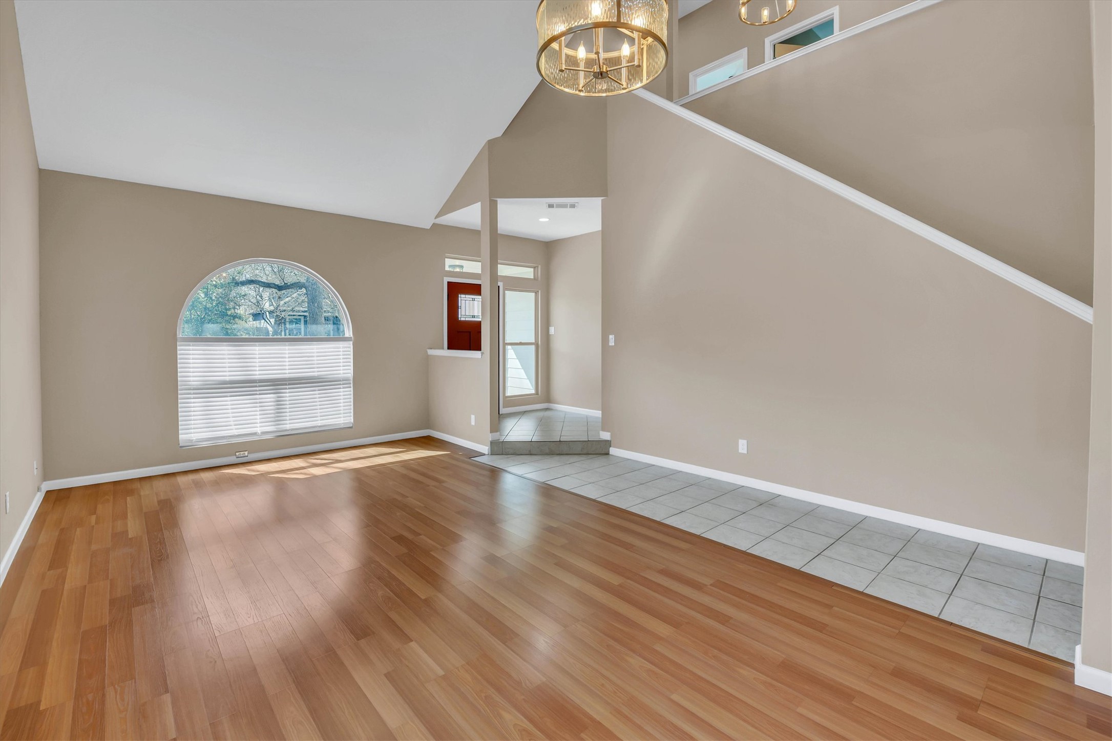 8108 Matchlock Cove Austin, TX 78729 - Photo 8 of 40 Unfurnished living room featuring suspended lighting, light wood-type flooring, plenty of natural light, and lofted ceiling