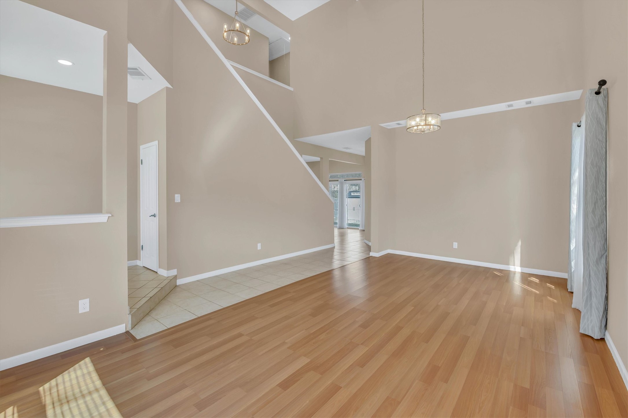 8108 Matchlock Cove Austin, TX 78729 - Photo 9 of 40 Unfurnished living room featuring hanging lights, a high ceiling, and light wood finished floors