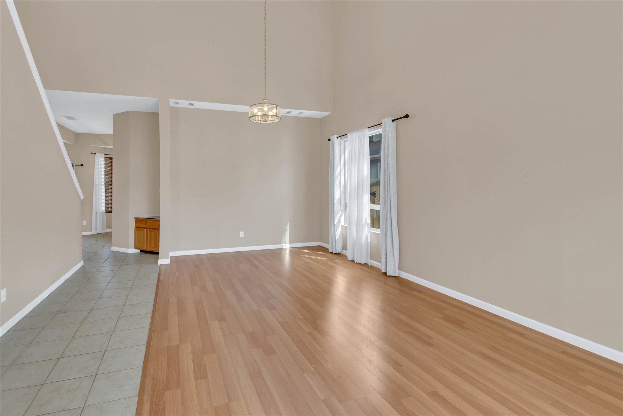 8108 Matchlock Cove Austin, TX 78729 - Photo 10 of 40 Spare room with light wood-type flooring, a high ceiling, suspended lighting, and healthy amount of natural light