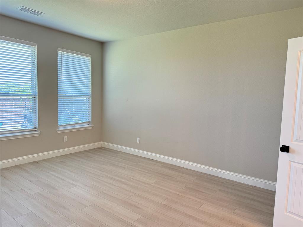 7308 Roaring Springs Road Arlington, TX 76002 - Photo 15 of 29 an empty room with wooden floor and windows