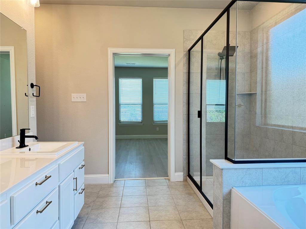 7308 Roaring Springs Road Arlington, TX 76002 - Photo 20 of 29 a bathroom with a double vanity sink a mirror and a shower