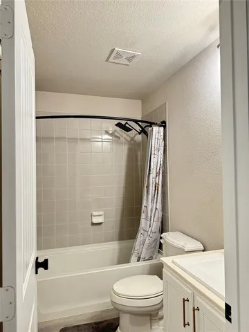 a bathroom with a granite countertop bathtub shower sink vanity and toilet