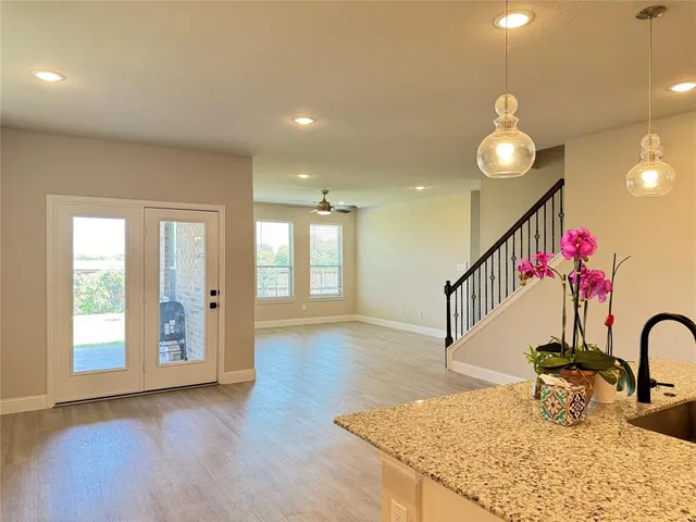 a view of a hallway with wooden floor and chandelier