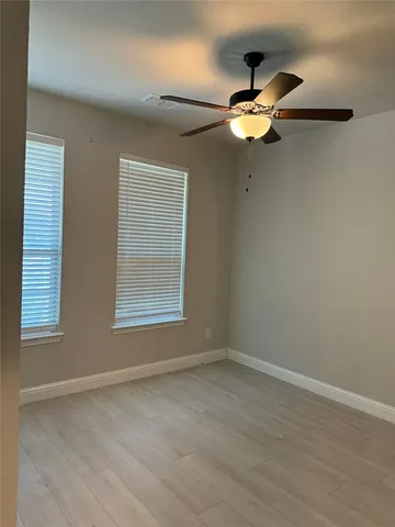 a view of wooden floor chandelier fan and windows in a room